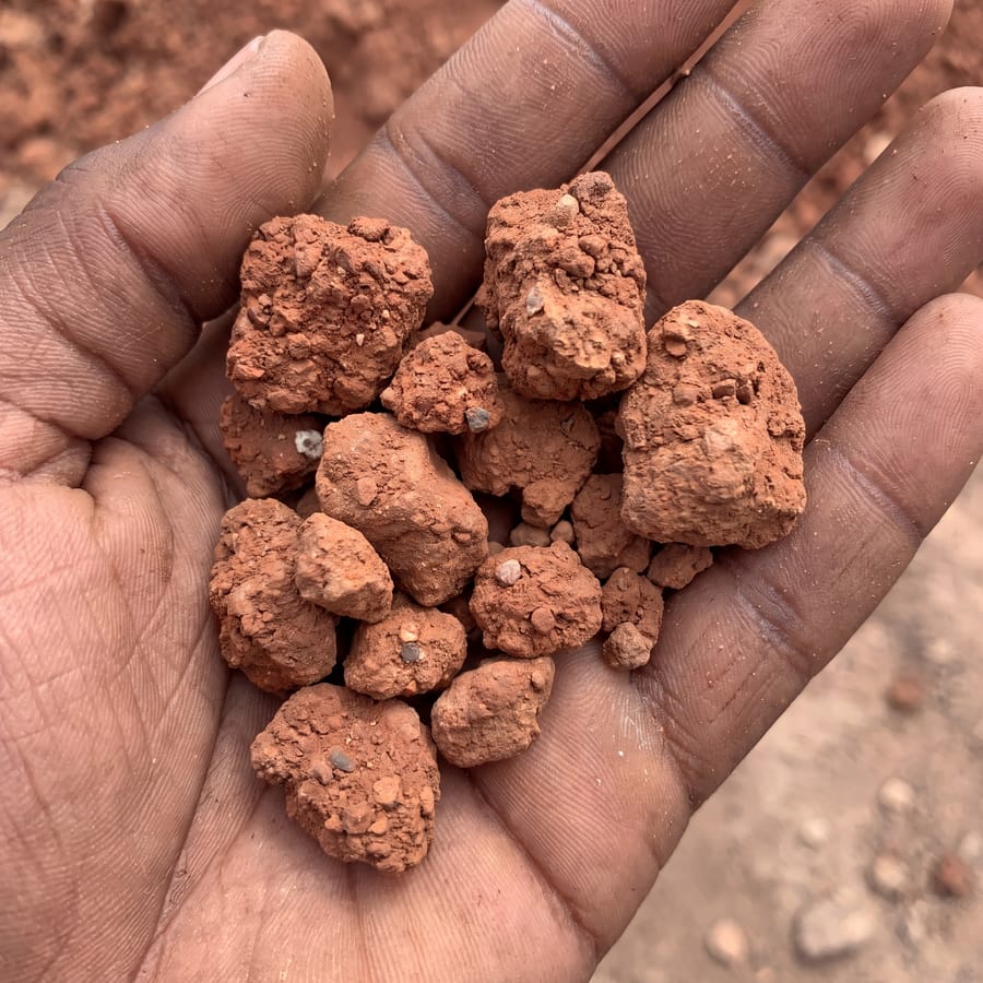 Laterite/fill texture close-up, hand for scale